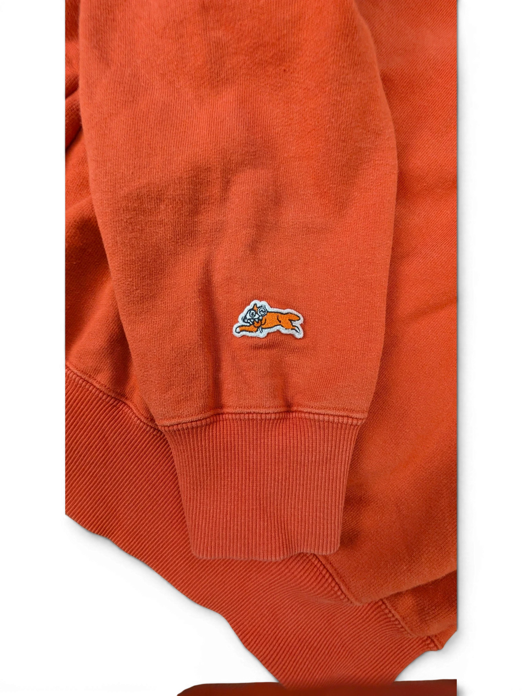 JAKE & IPI Icecream zip hoodie in bright orange featuring a small embroidered running dog logo on the sleeve cuff.