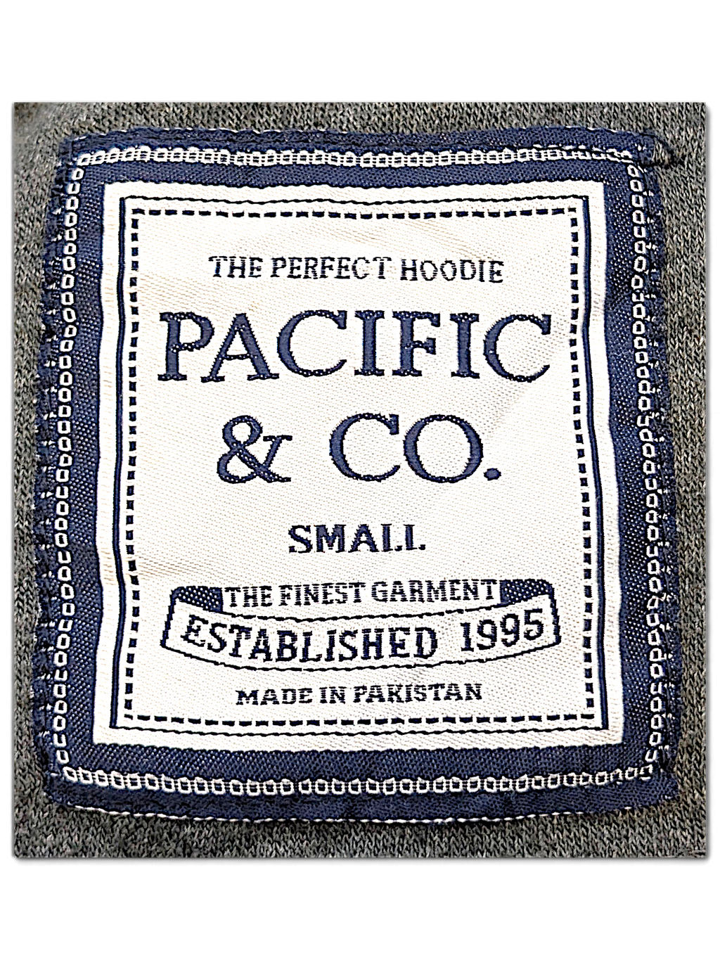 JAKE & IPI Pacific & CO College hoodie interior neck label in white and navy on a grey fleece fabric background