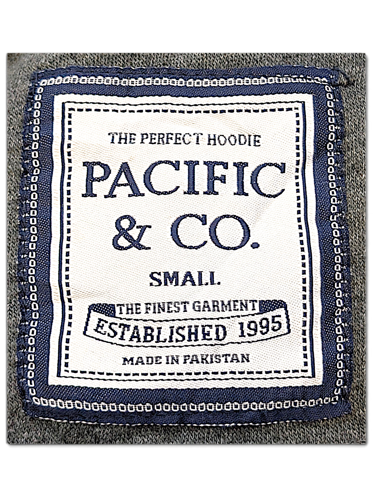 JAKE & IPI Pacific & CO College hoodie interior neck label in white and navy on a grey fleece fabric background