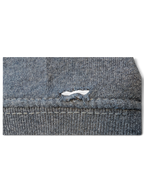 Close-up of a JAKE & IPI Pismo Beach Hoodie showing a small tear in the grey heathered fabric near the seam.