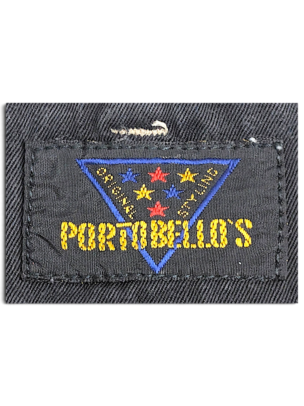 JAKE & IPI Portobello’s clothing brand label featuring a blue triangle with colorful stars on a black fabric background