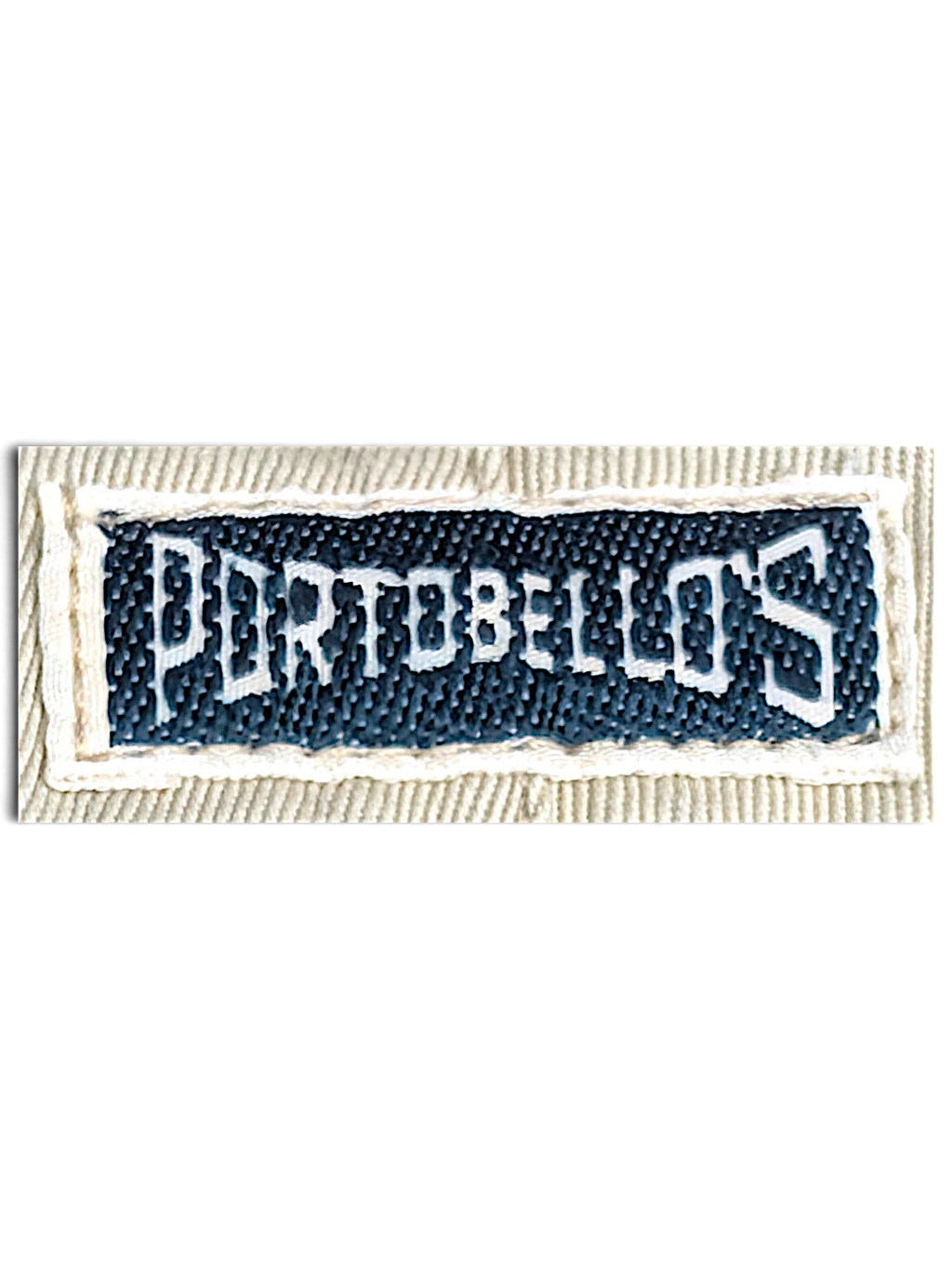 JAKE & IPI Portobello’s brand clothing label stitched on beige fabric