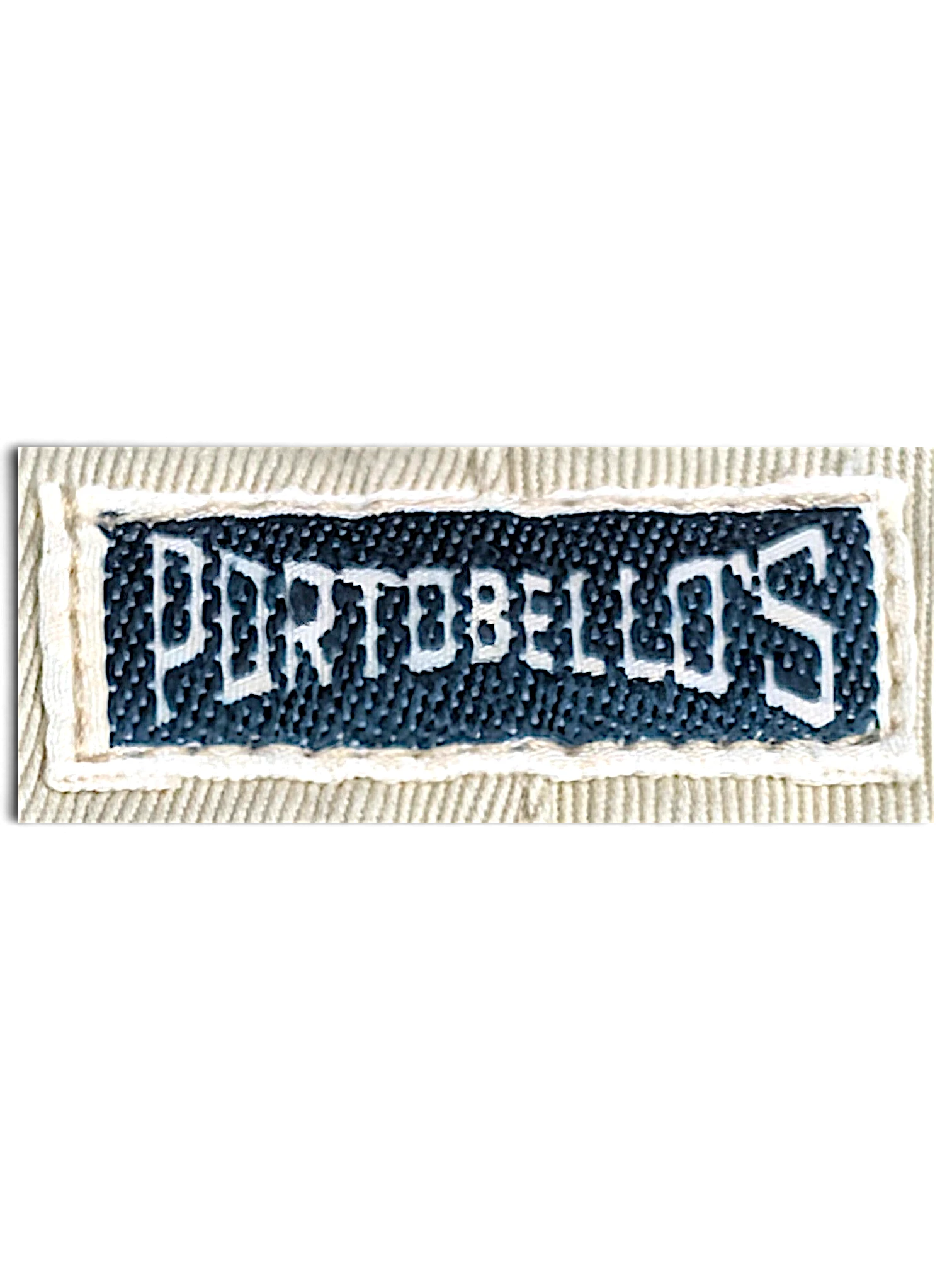 JAKE & IPI Portobello’s brand clothing label stitched on beige fabric