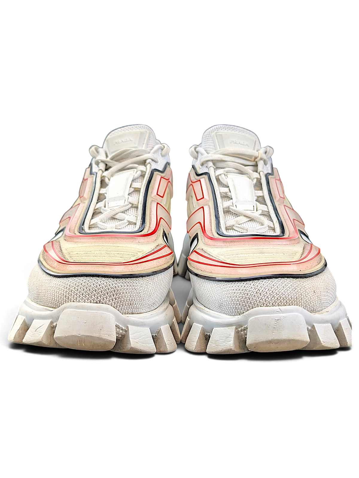 Prada Cloudbust Thunder sneakers showing white knit uppers and red-orange rubber cage