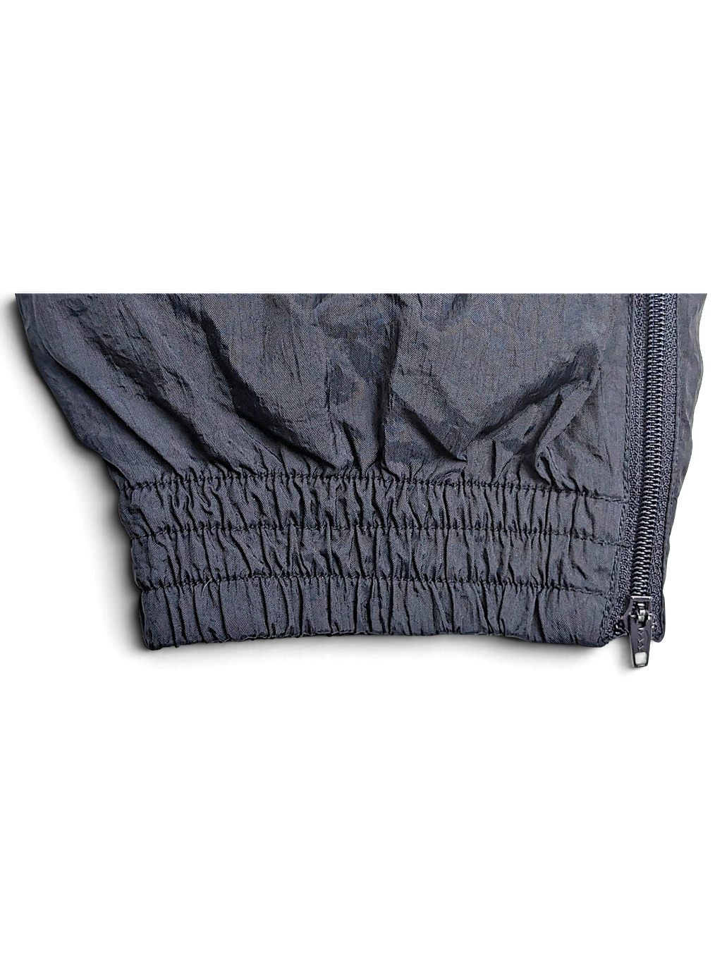 JAKE & IPI Puma black track pants featuring a gathered elastic ankle cuff with a side zipper detail.