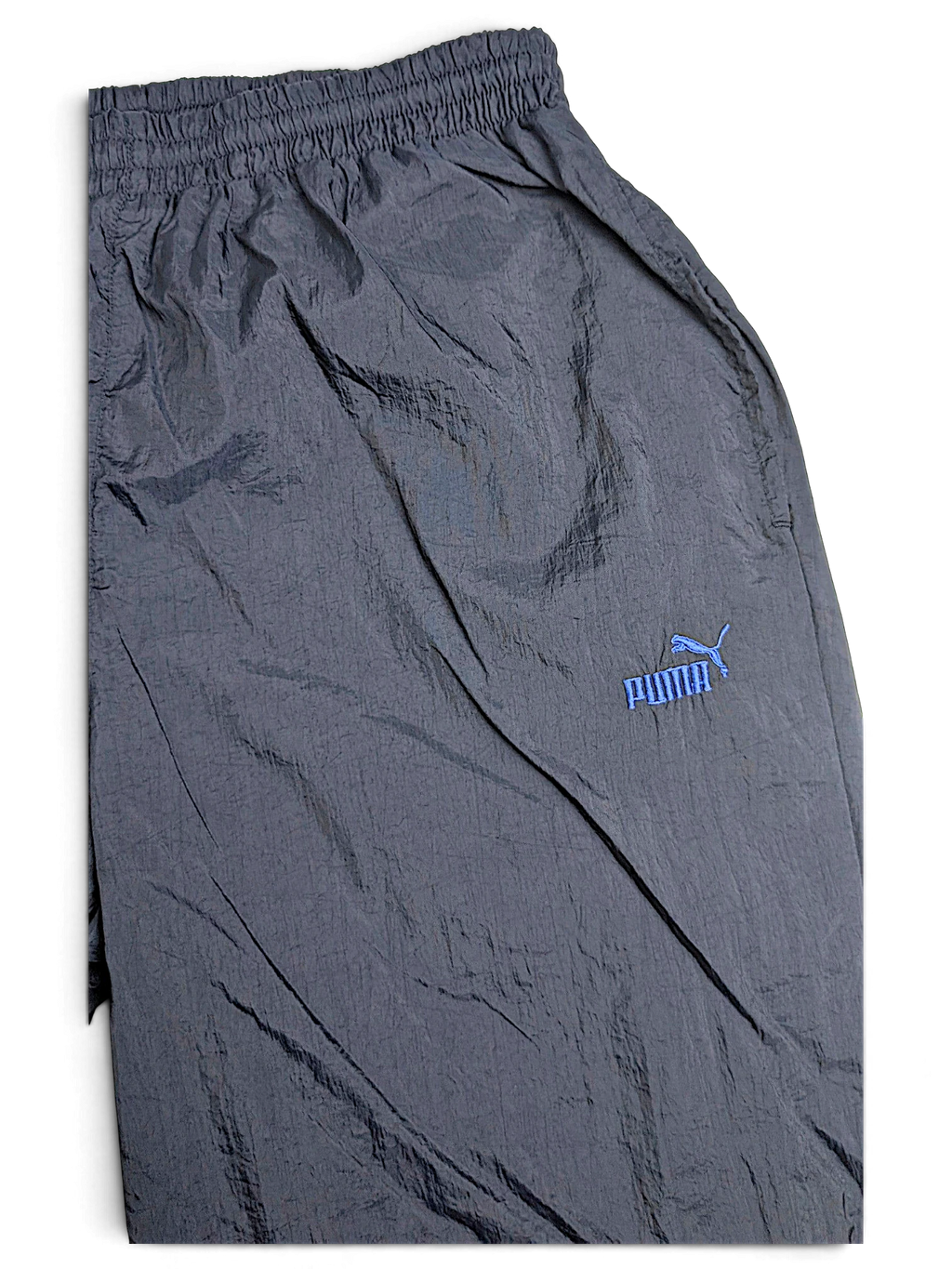 JAKE & IPI pre-owned black Puma track pants with light blue logo, elastic waist, and lightweight fabric construction.