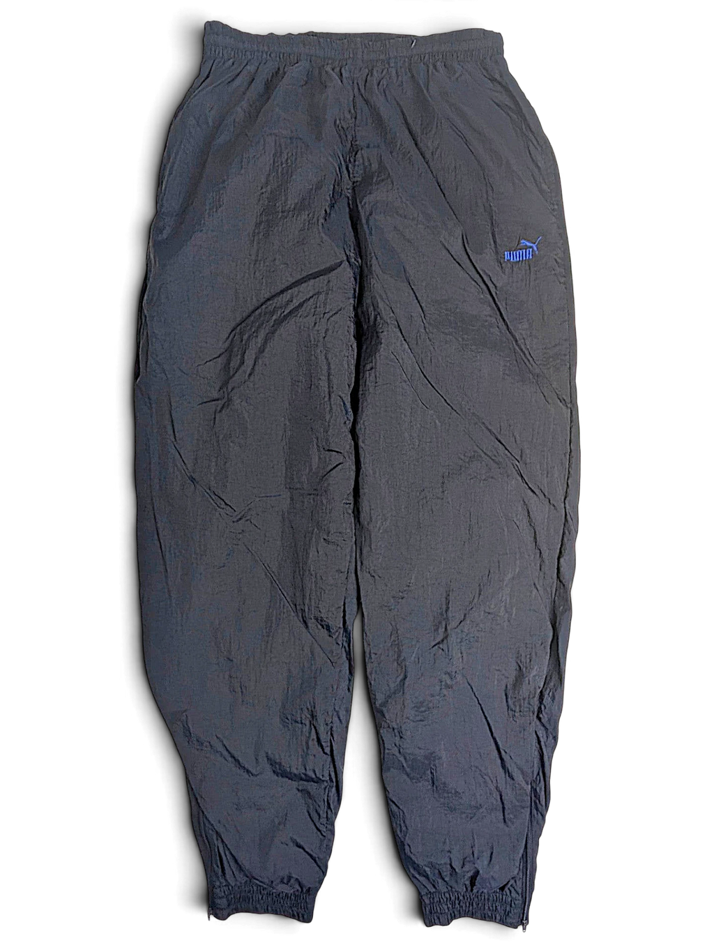 JAKE & IPI pre-owned black Puma track pants with a light blue logo, elastic waist, and lightweight fabric construction.
