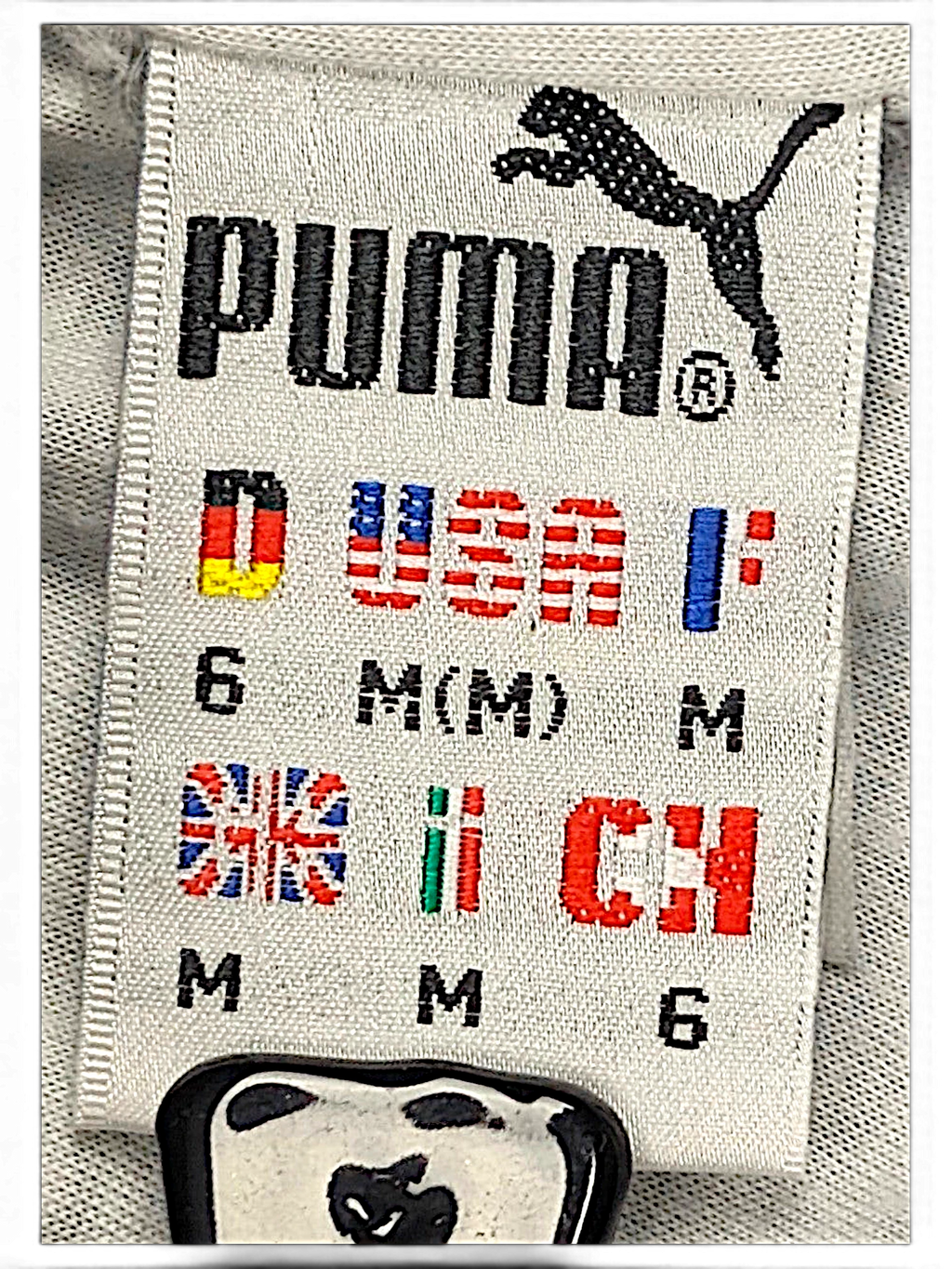 JAKE & IPI Puma track pants size label showing size M and international sizing flags