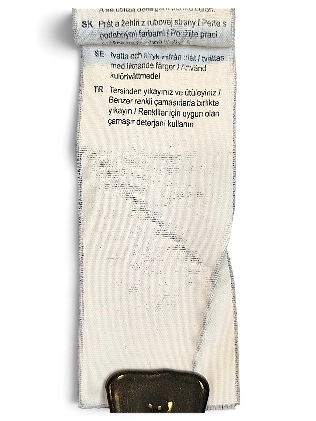 JAKE & IPI Puma track pants care label with washing instructions in multiple languages on a white fabric tag.