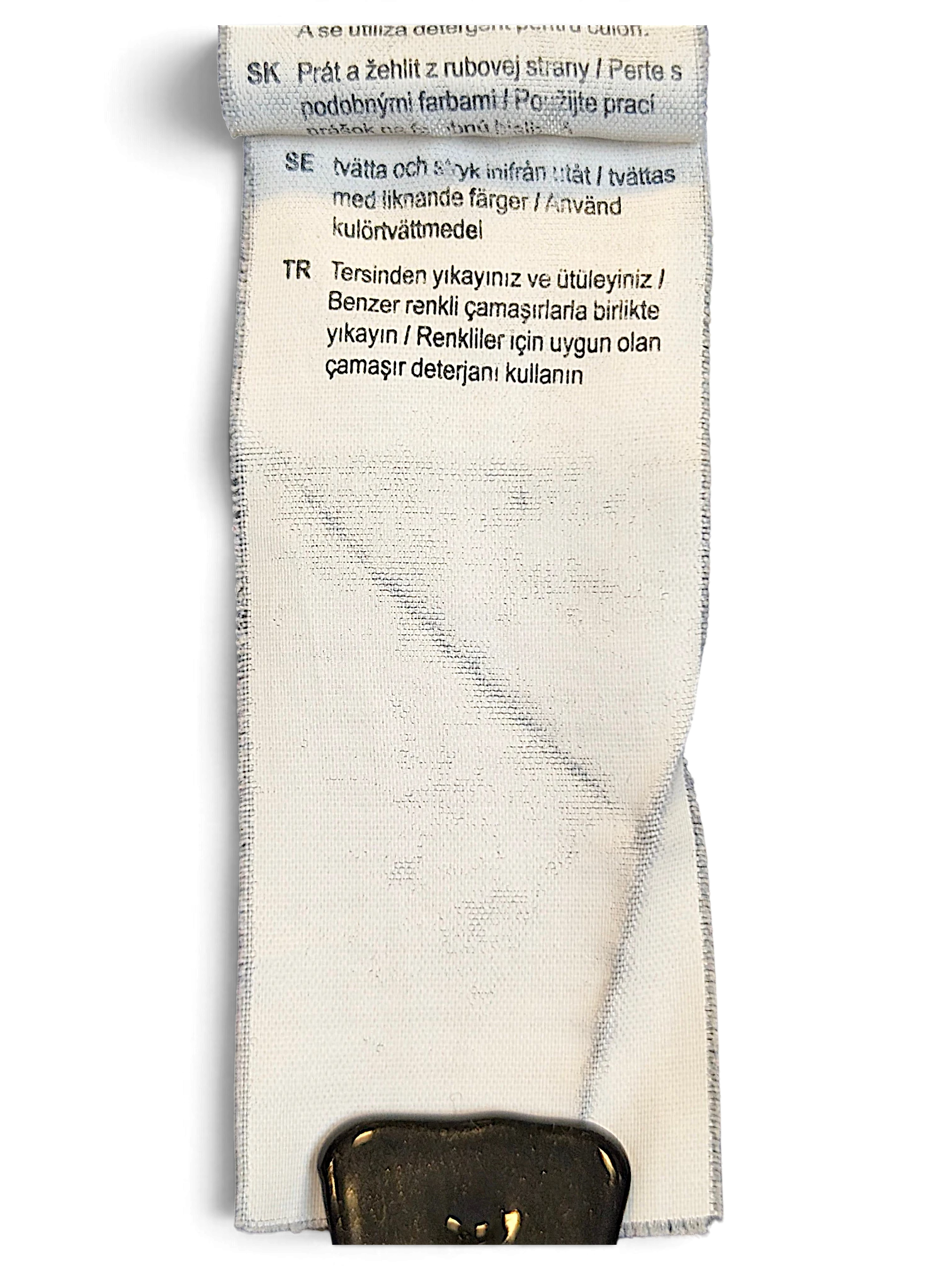 JAKE & IPI Puma track pants care label with washing instructions in multiple languages on a white fabric tag.