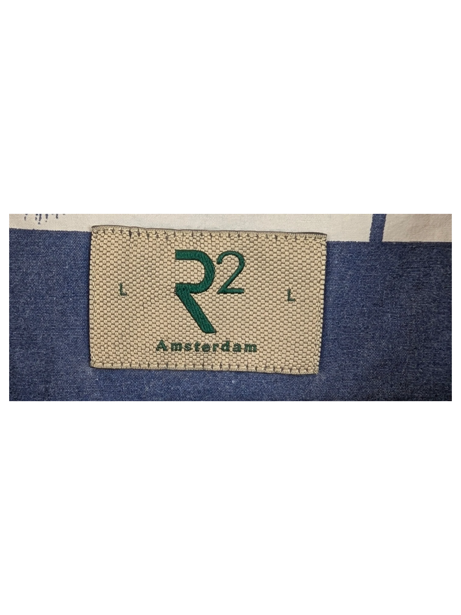 JAKE & IPI R2 Amsterdam Hawaiian shirt featuring a blue and white palm tree print on a wooden hanger