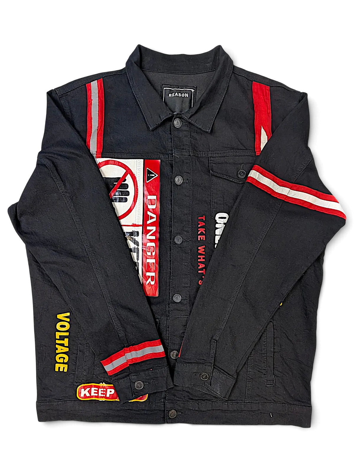 JAKE & IPI Reason black denim jacket featuring red and yellow warning-themed patches and reflective stripe details.