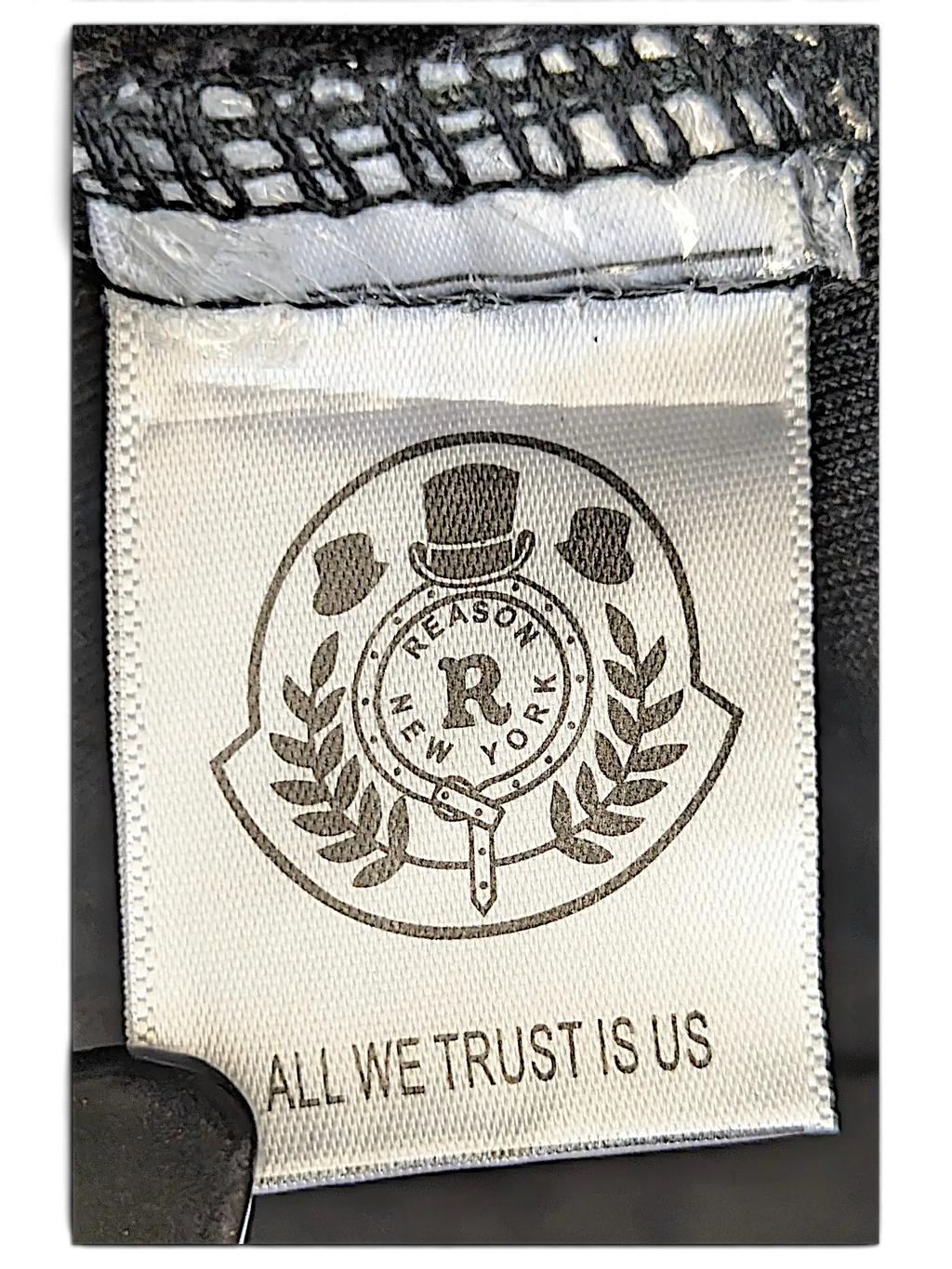 JAKE & IPI Reason denim jacket interior brand label featuring the Reason New York logo and All We Trust Is Us text