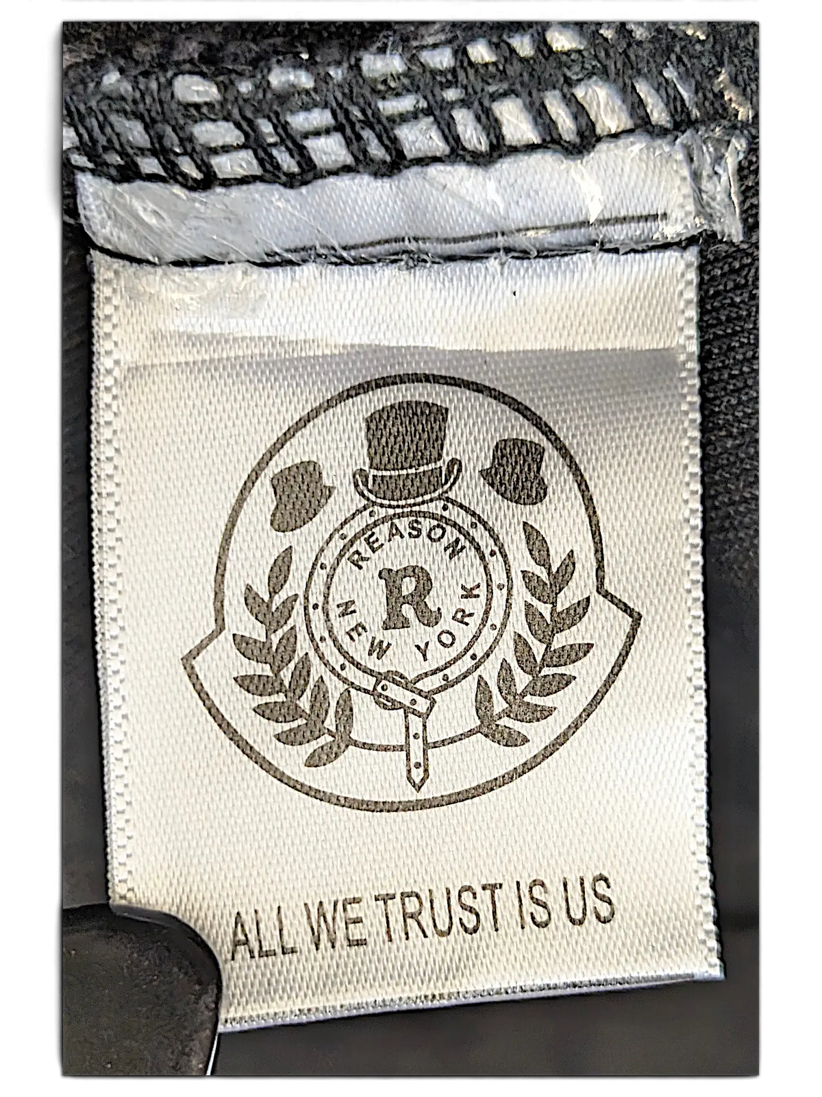 JAKE & IPI Reason denim jacket interior brand label featuring the Reason New York logo and All We Trust Is Us text