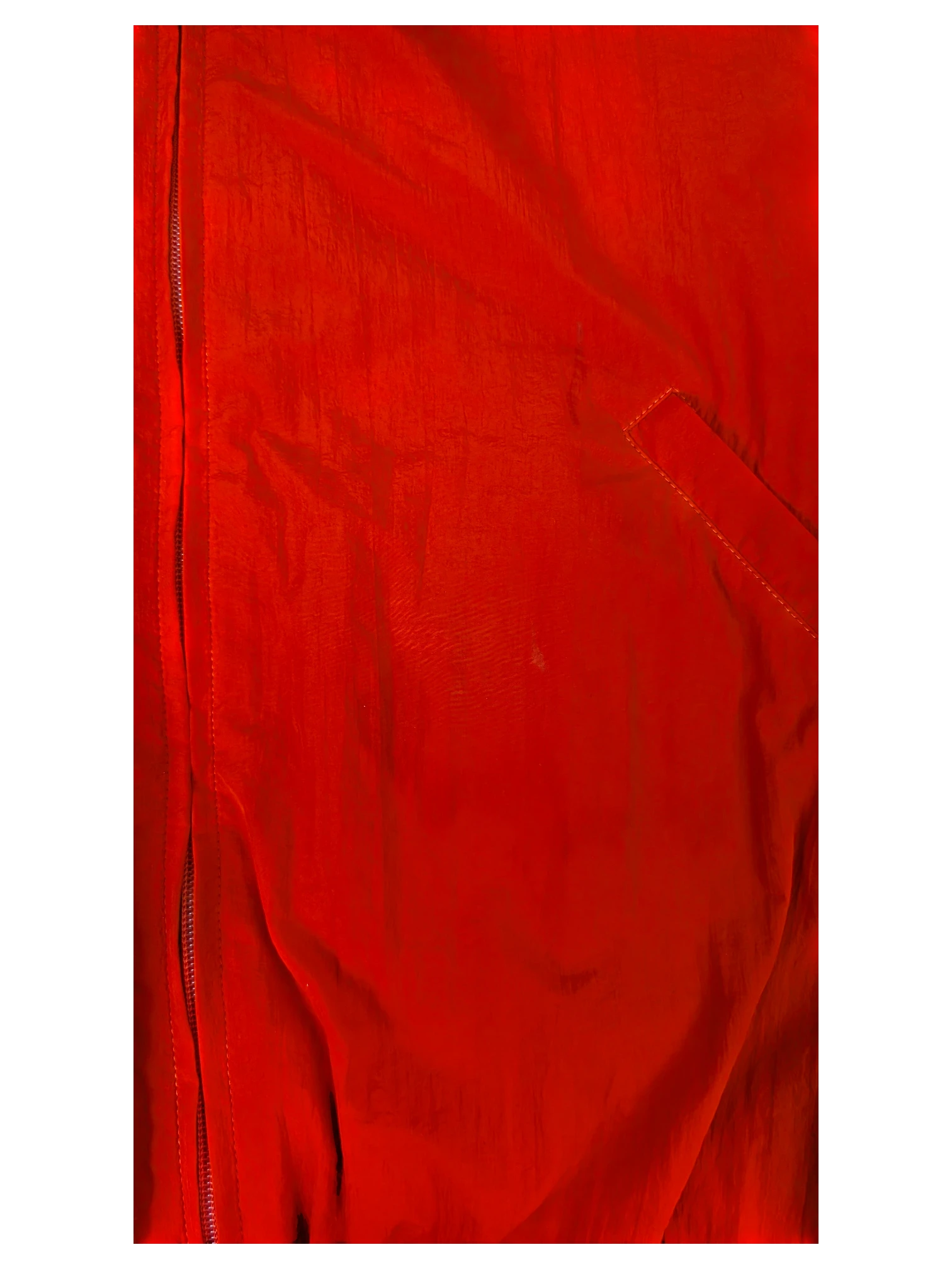 Close-up of a red JAKE & IPI Balenciaga x Adidas jacket featuring a front zipper and textured fabric detail.