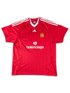 JAKE & IPI red Balenciaga x Adidas collaborative soccer jersey with white stripes and logo detailing