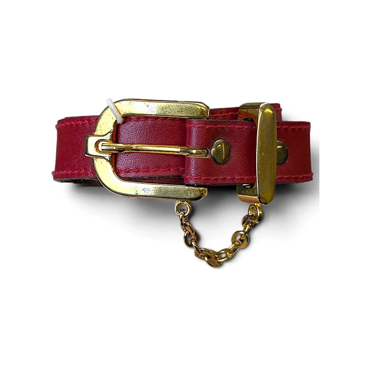 JAKE & IPI red leather belt featuring a polished gold buckle and decorative gold chain detail held in a hand.