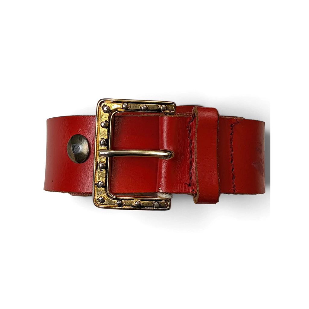 JAKE & IPI red leather belt featuring a gold-tone buckle with decorative silver studs held in a hand.