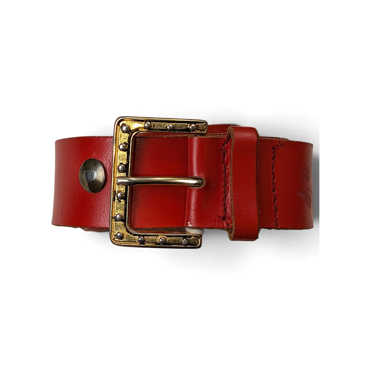 JAKE & IPI red leather belt featuring a gold-tone buckle with decorative silver studs held in a hand.