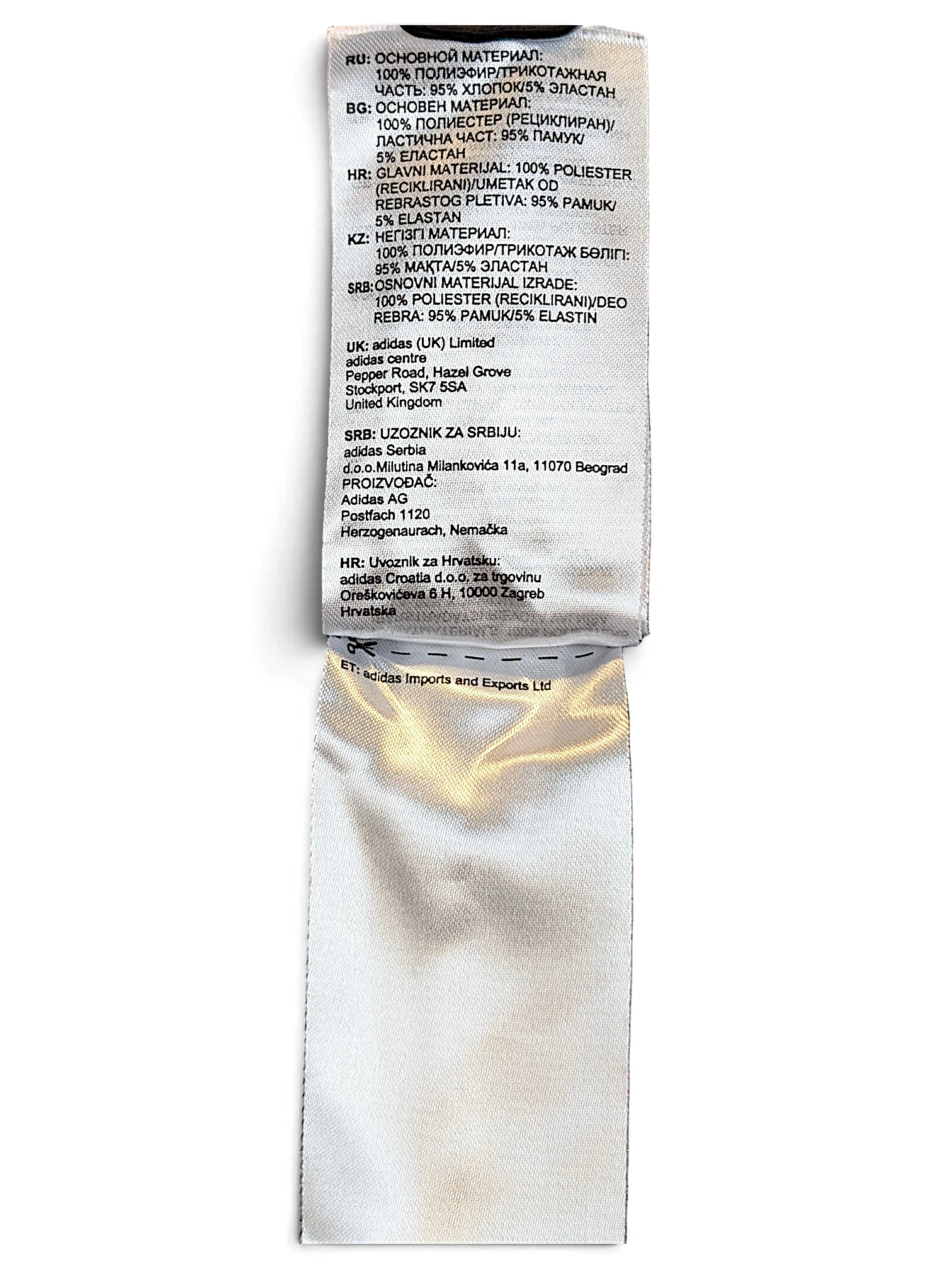 JAKE & IPI Reebok track pants care label showing fabric composition and manufacturing details in multiple languages
