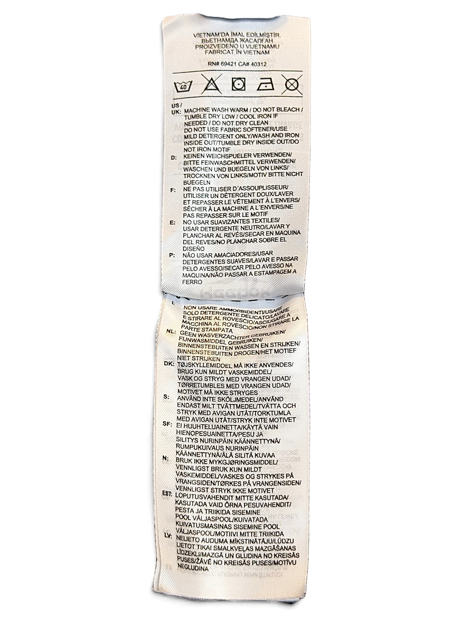 JAKE & IPI Reebok track pants care label with washing instructions in multiple languages