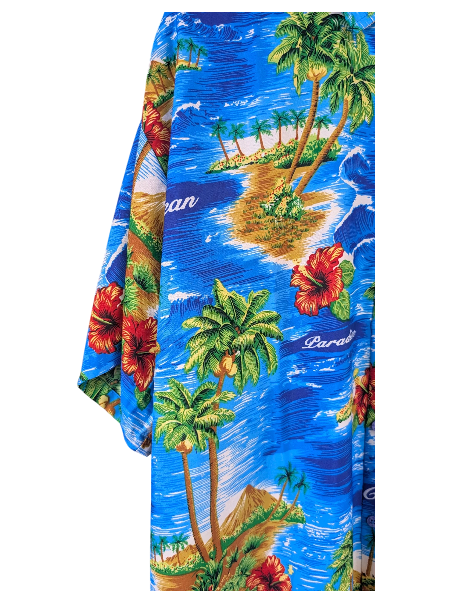 JAKE & IPI Rima Hawaiian shirt featuring a vibrant blue tropical print with palm trees, hibiscus flowers, and islands.
