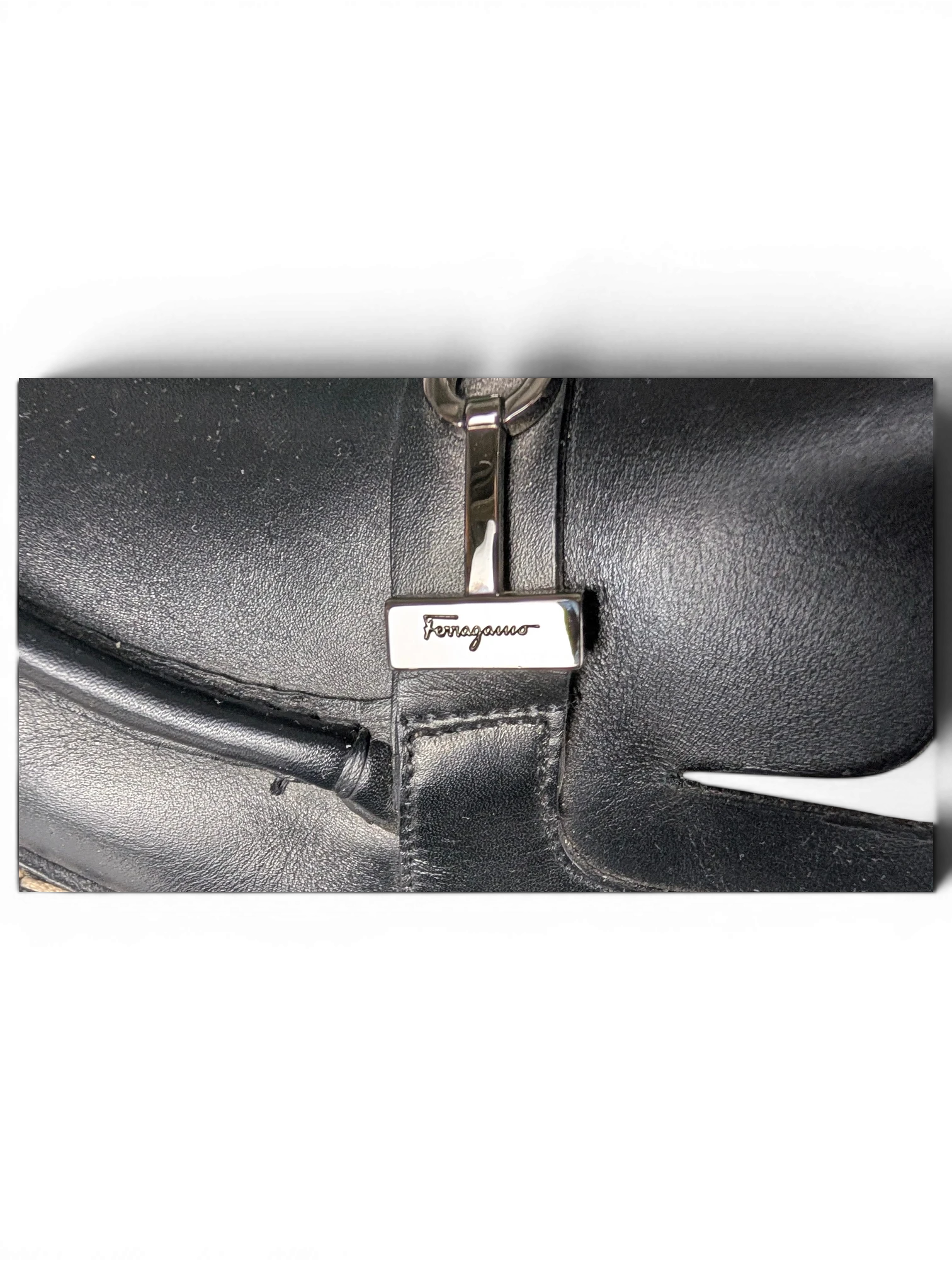JAKE & IPI black leather Salvatore Ferragamo loafers featuring silver-tone metal hardware detail on the upper.