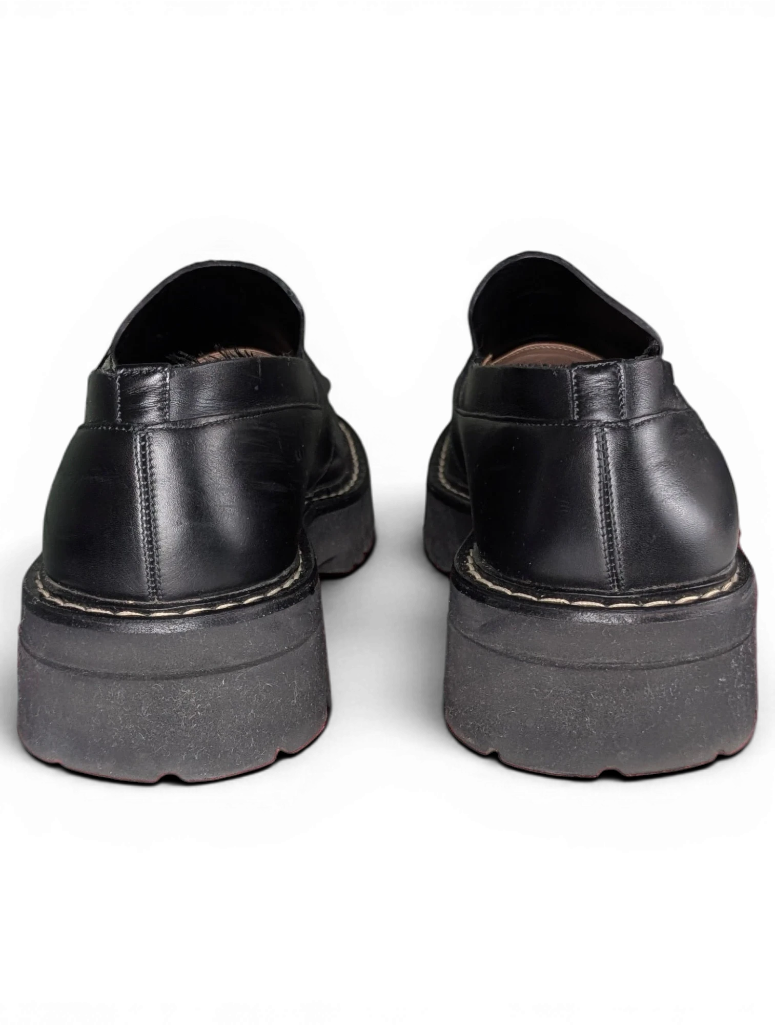 Back view of black leather Salvatore Ferragamo loafers with chunky rubber soles from JAKE & IPI