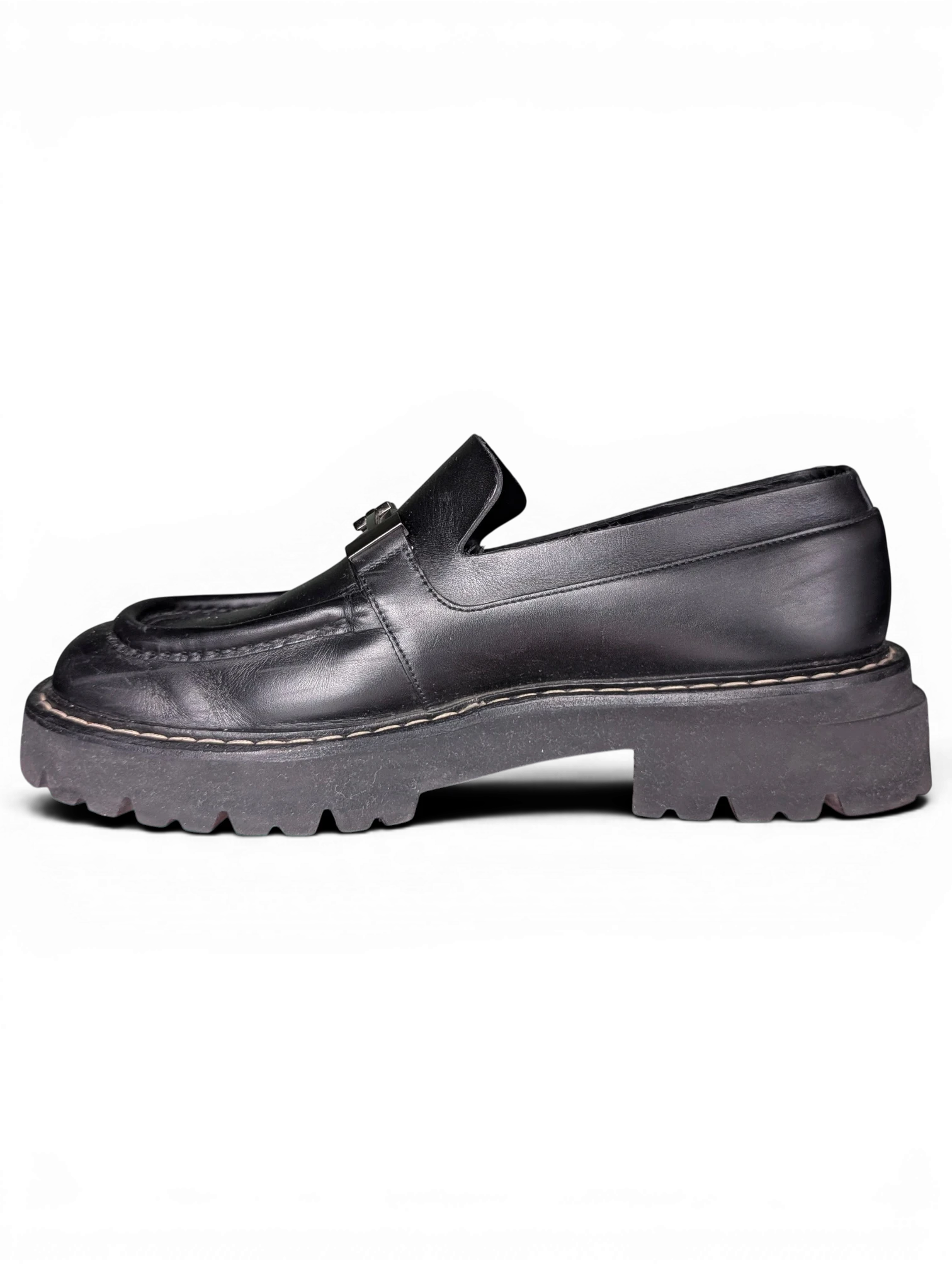 JAKE & IPI Salvatore Ferragamo black leather loafers with metal hardware and chunky rubber lug soles, side view.