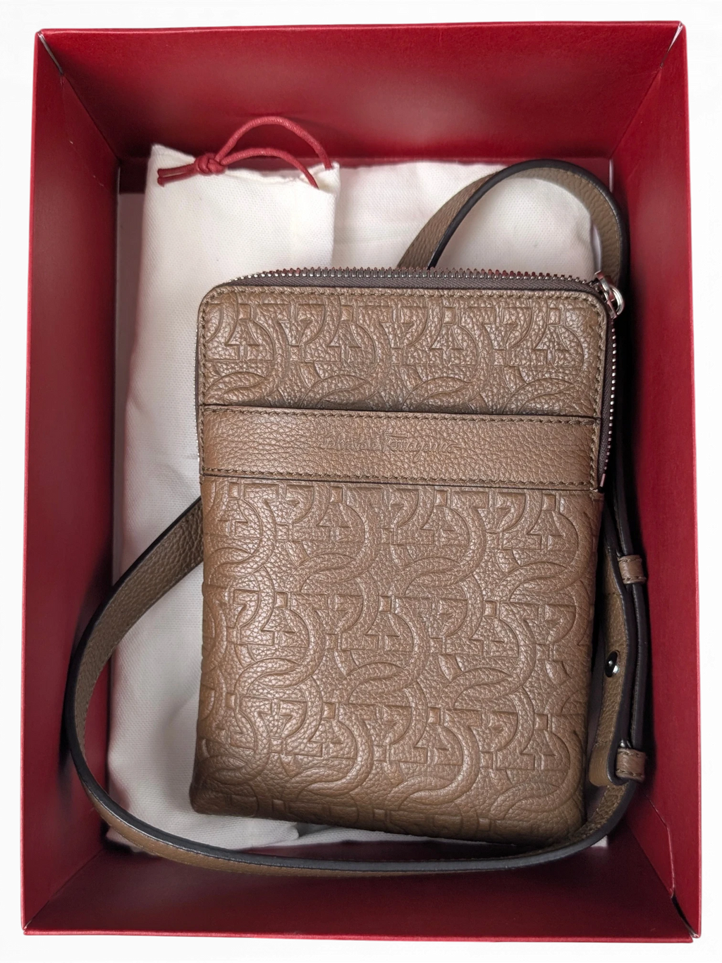 JAKE & IPI Salvatore Ferragamo brown leather messenger bag with embossed Gancini logo pattern in a red gift box.