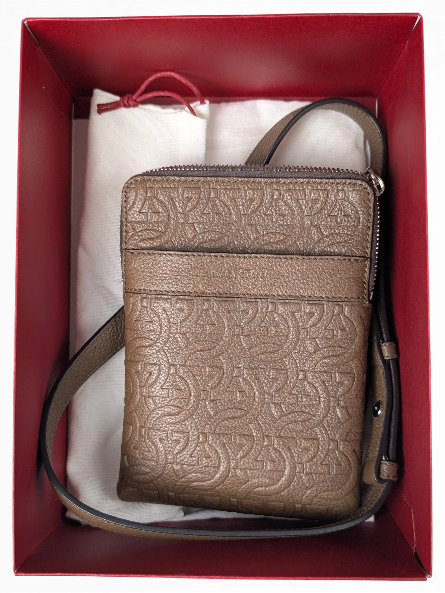JAKE & IPI Salvatore Ferragamo brown leather messenger bag with embossed Gancini logo pattern in a red gift box.