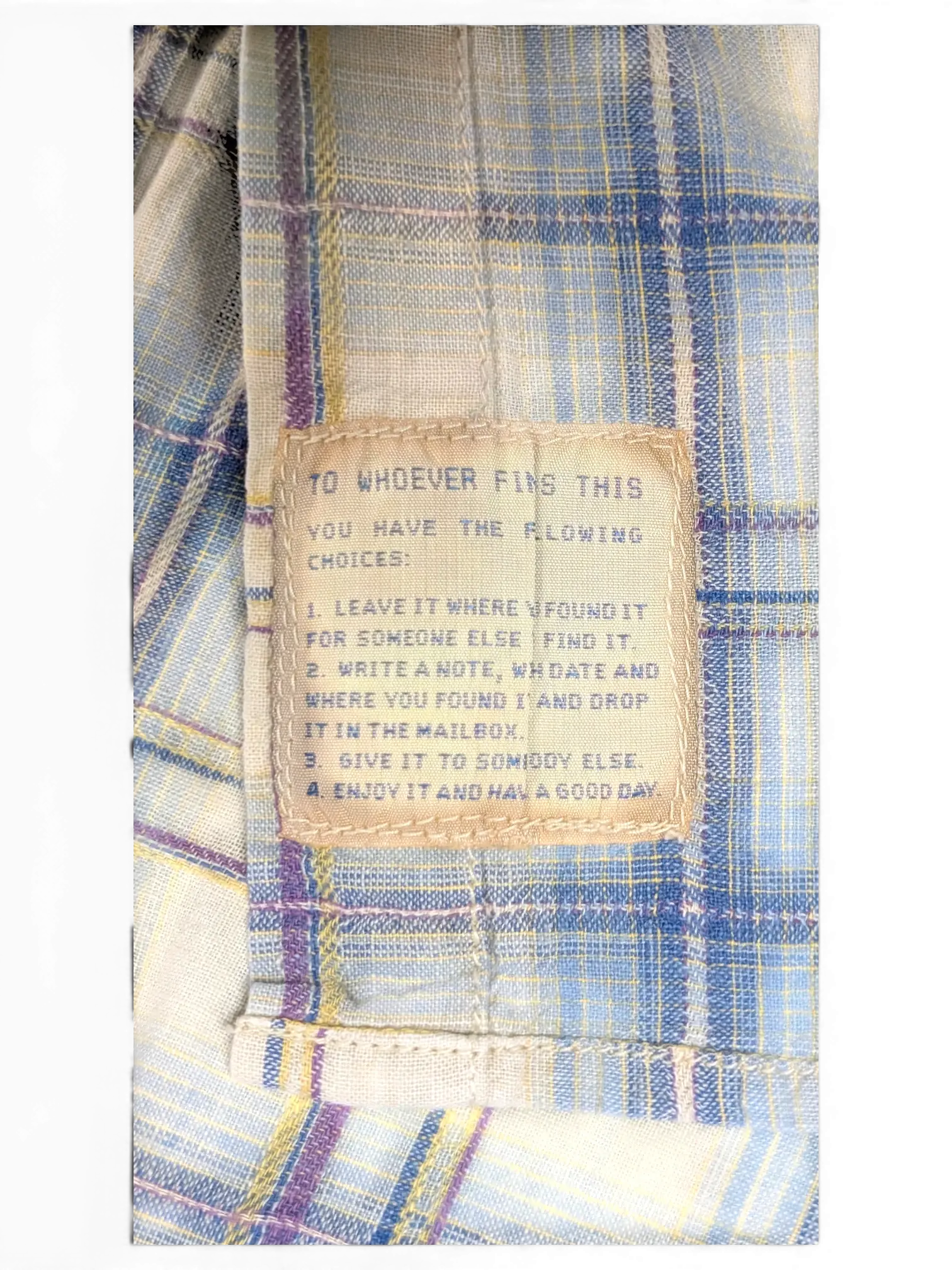 JAKE & IPI Scotch & Soda plaid shirt featuring a unique internal message patch on beige, blue, and burgundy fabric.