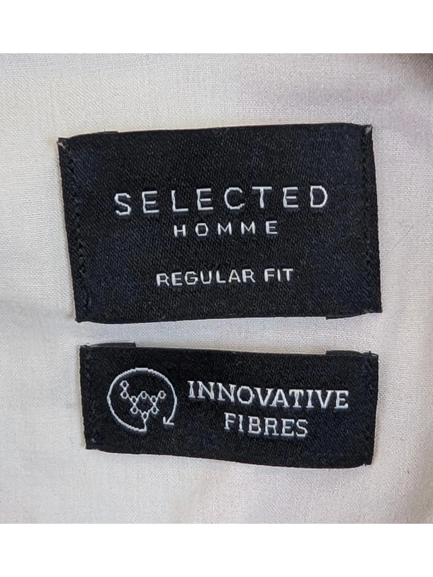 JAKE & IPI Selected Homme Hawaiian shirt label showing regular fit and innovative fibres branding on a wooden hanger