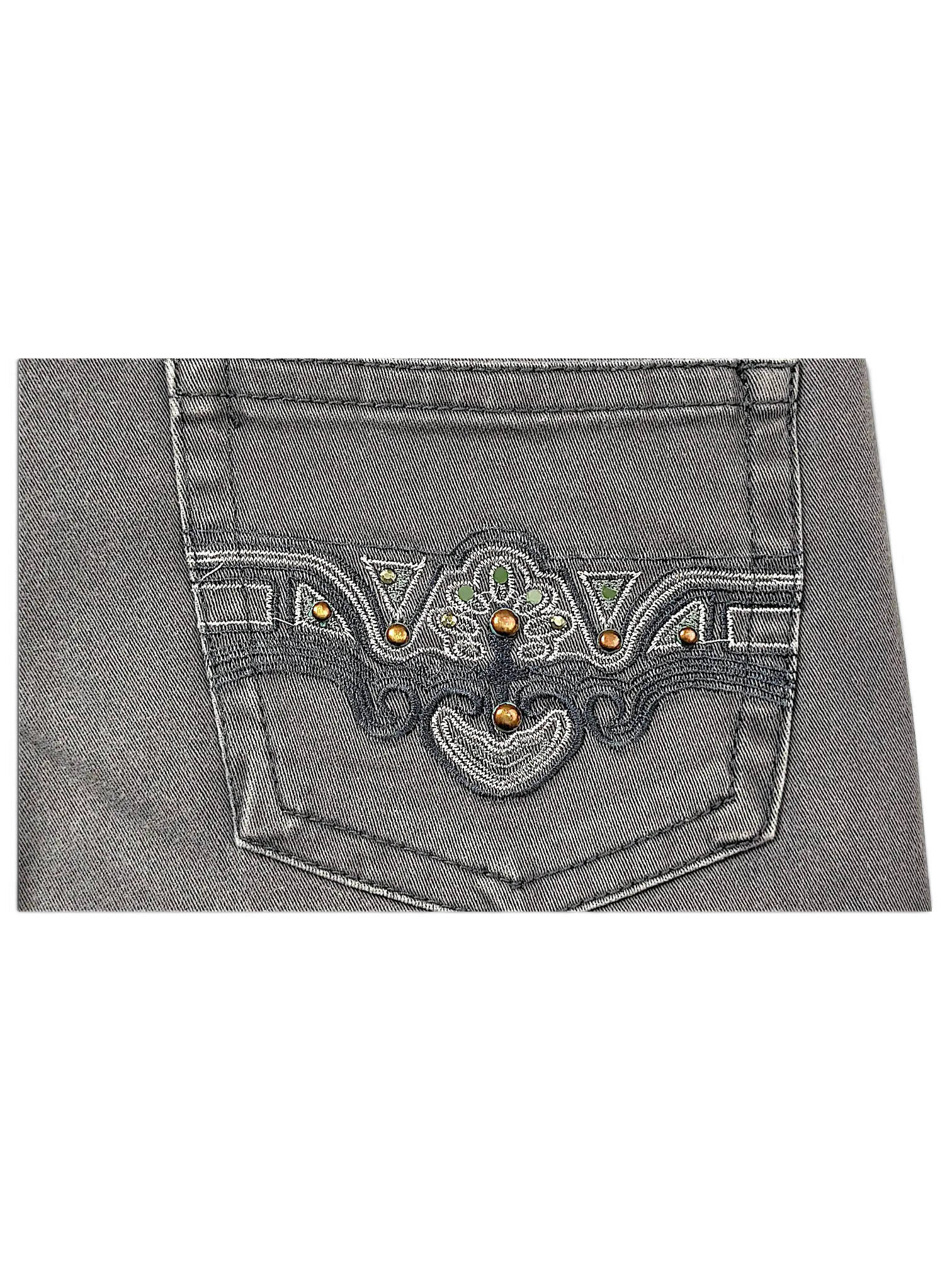 JAKE & IPI Seyoo Denim Division Y2K jeans back pocket featuring intricate dark embroidery, studs, and green accents.