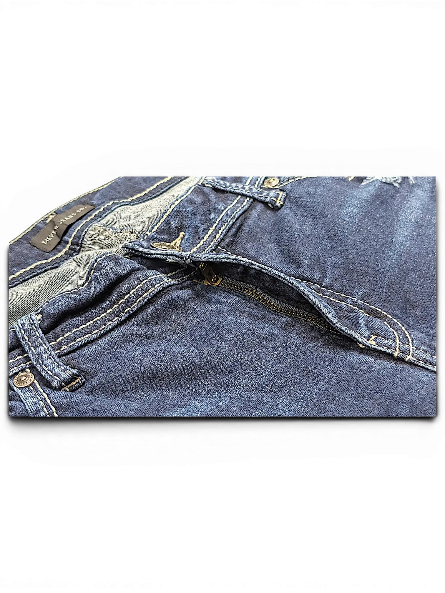 JAKE & IPI Silver Jeans Co. Suki Capri denim jeans featuring dark blue wash, contrast stitching, and zipper fly.