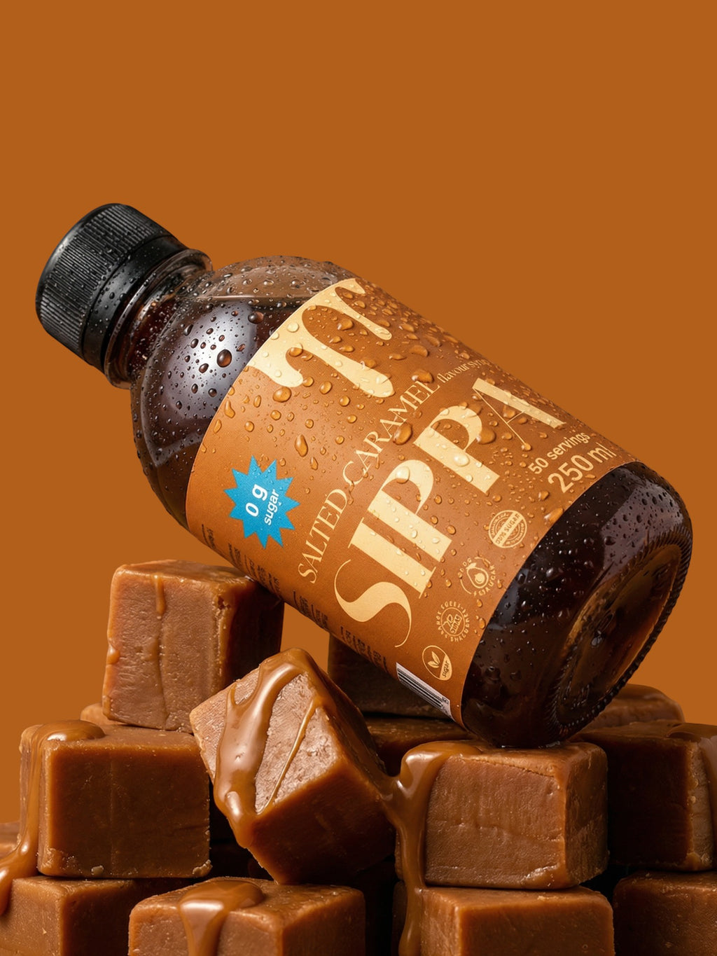 JAKE & IPI SIPPA Salted Caramel sugar-free syrup bottle resting on a stack of caramel cubes with caramel drizzle.