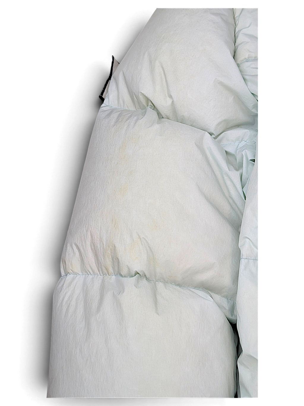 Stone Island pale blue down coat showing a visible fabric stain