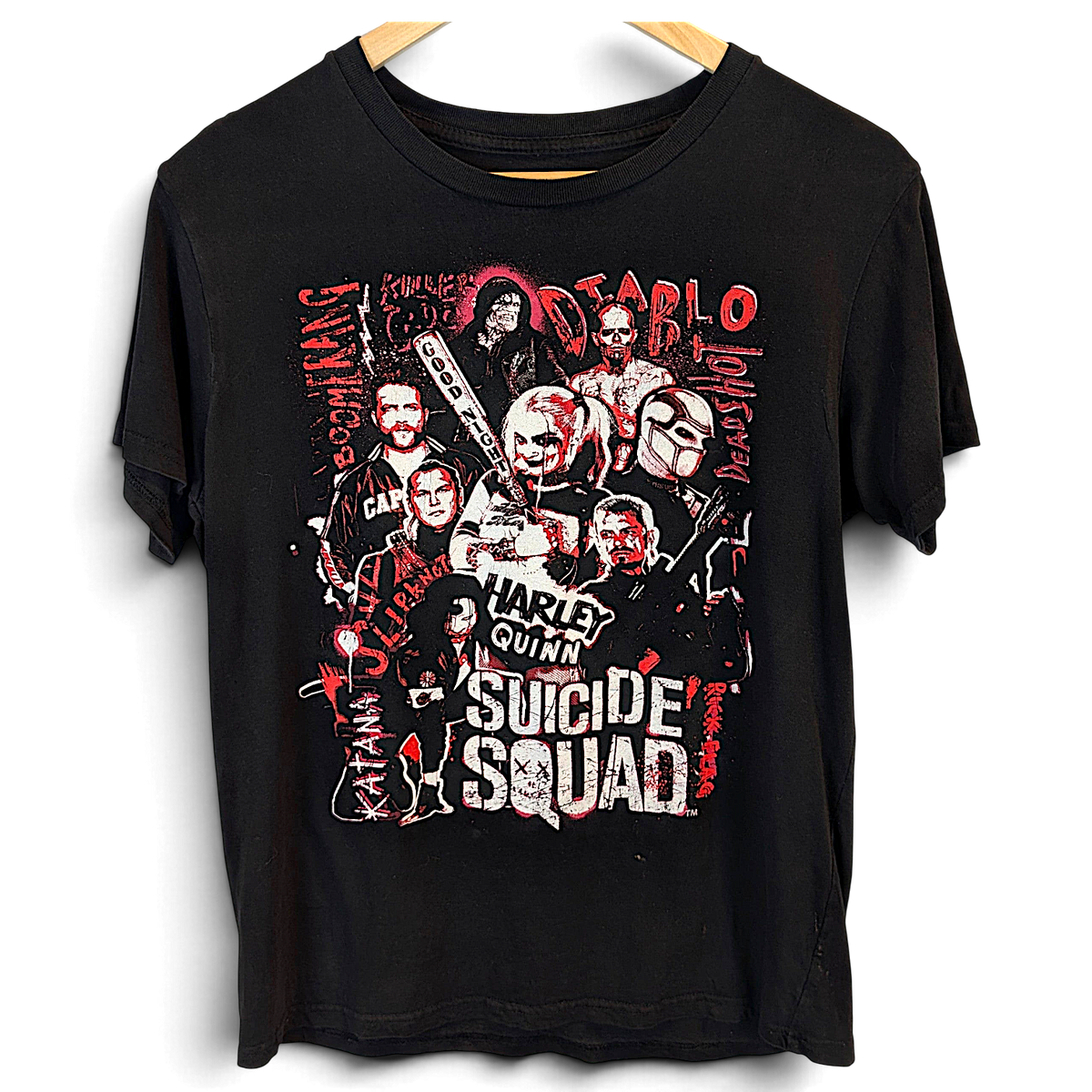 Musta lyhythihainen Suicide Squad -t-paita, jossa on punavalkoinen hahmografiikka ja pyöreä pääntie.