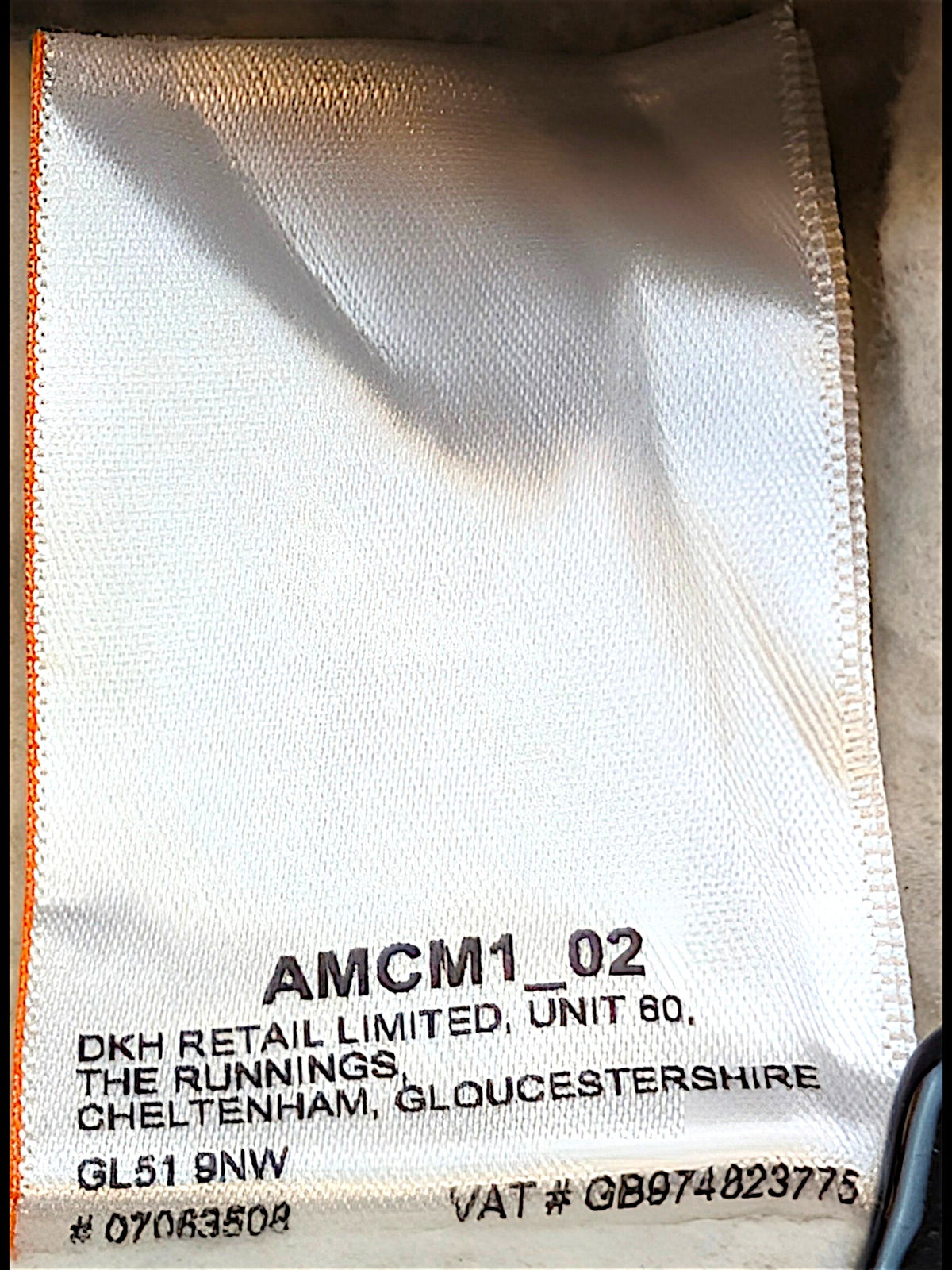 JAKE & IPI Superdry College garment care label with white fabric and black text detailing manufacturer information