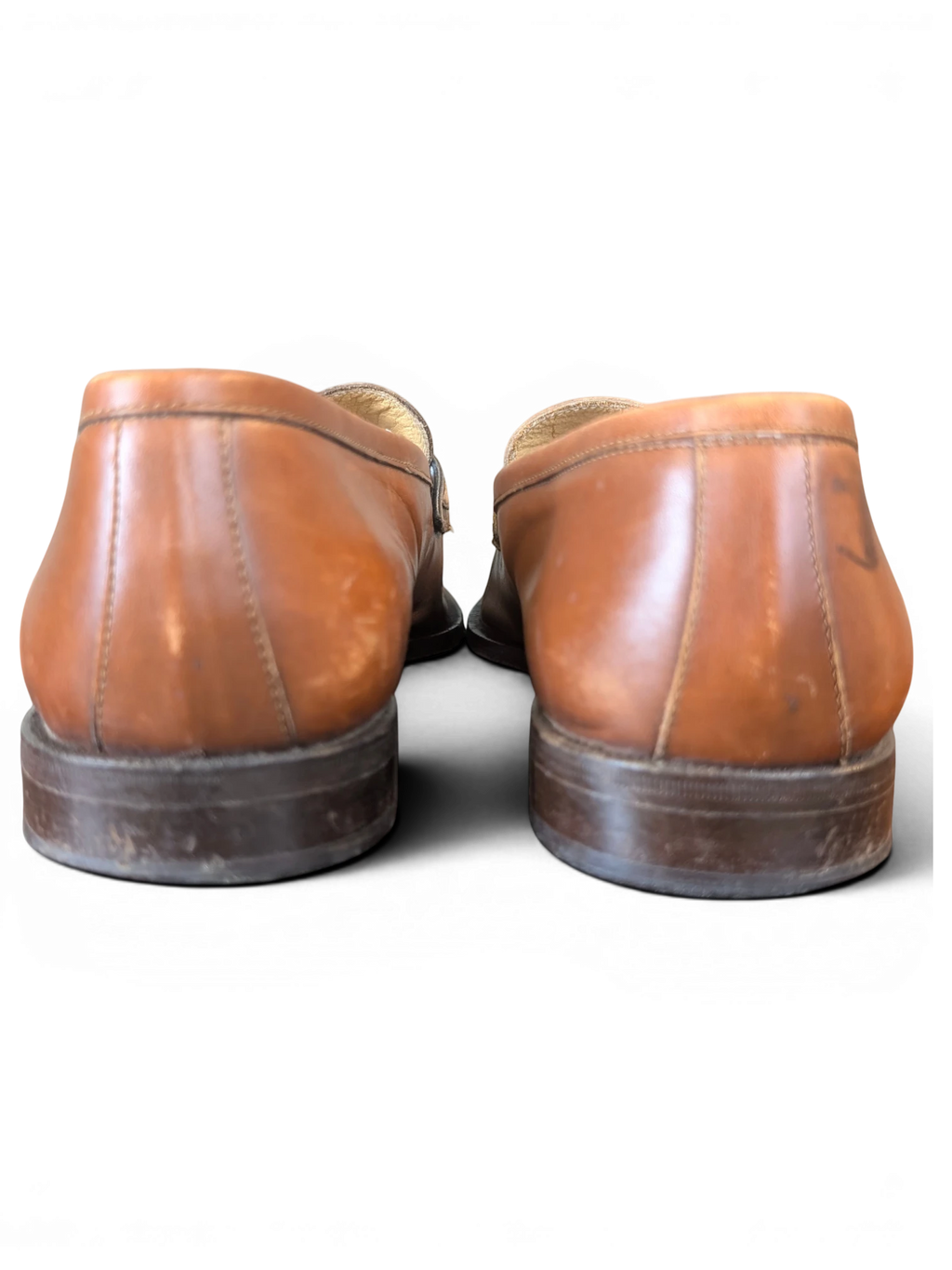 Rear view of JAKE & IPI tan leather loafers with stacked wooden heels against a black background