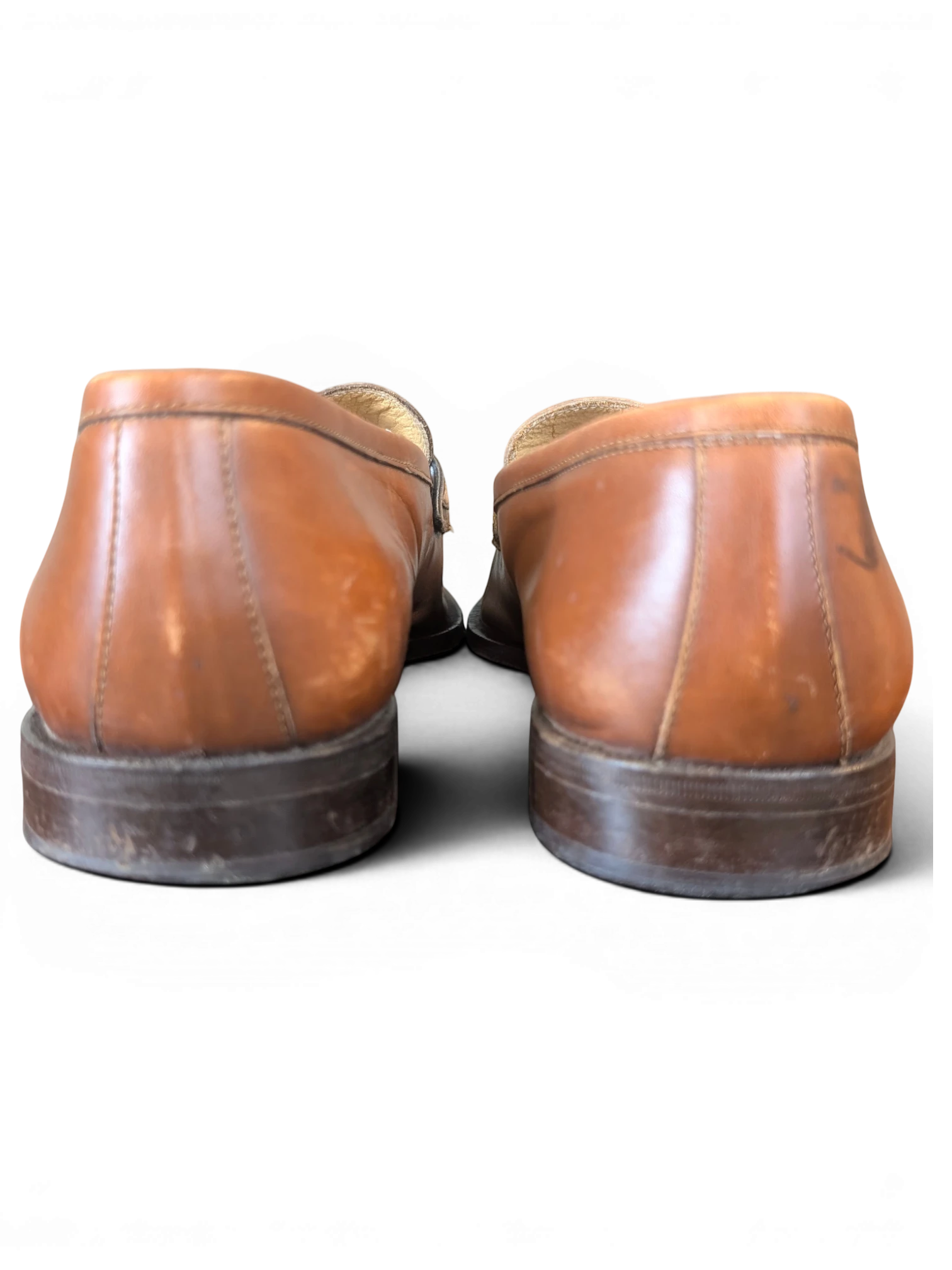 Rear view of JAKE & IPI tan leather loafers with stacked wooden heels against a black background