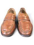JAKE & IPI tan leather penny loafers with classic moccasin stitching on a dark wooden surface