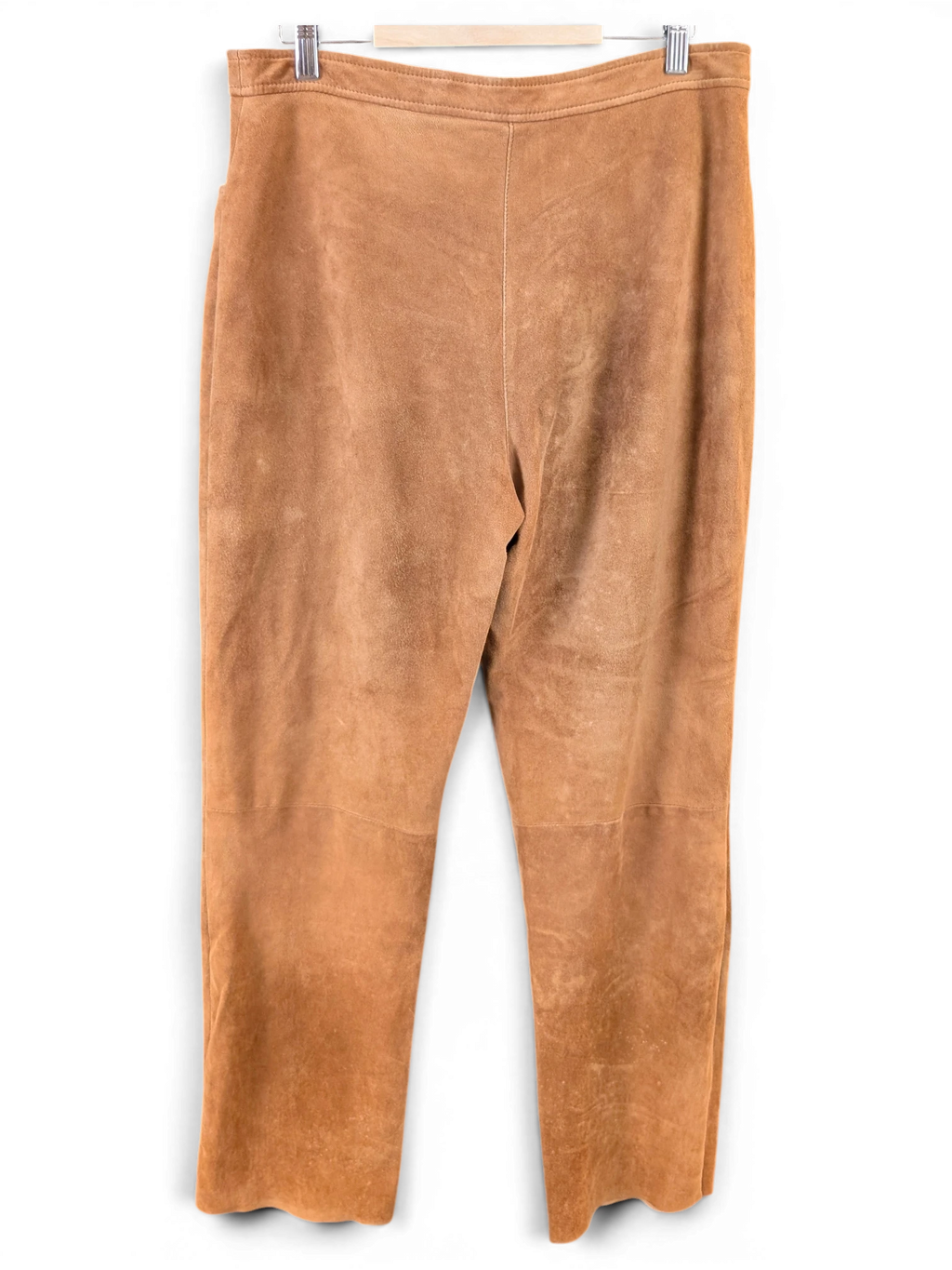 JAKE & IPI tan suede reindeer leather pants hanging on a hanger against a grey background