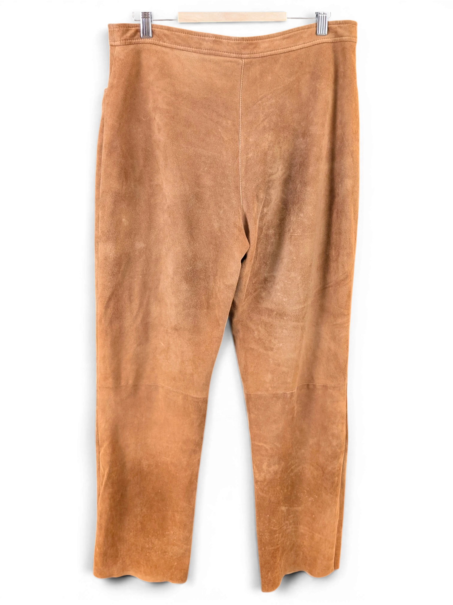 JAKE & IPI tan suede reindeer leather pants hanging on a hanger against a grey background