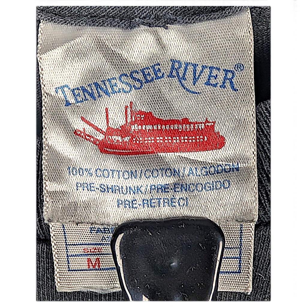 Jake & Ipi Tennessee River -t-paidan vaatteen sisäpuolen kokolappu, jossa näkyy materiaali ja koko M.