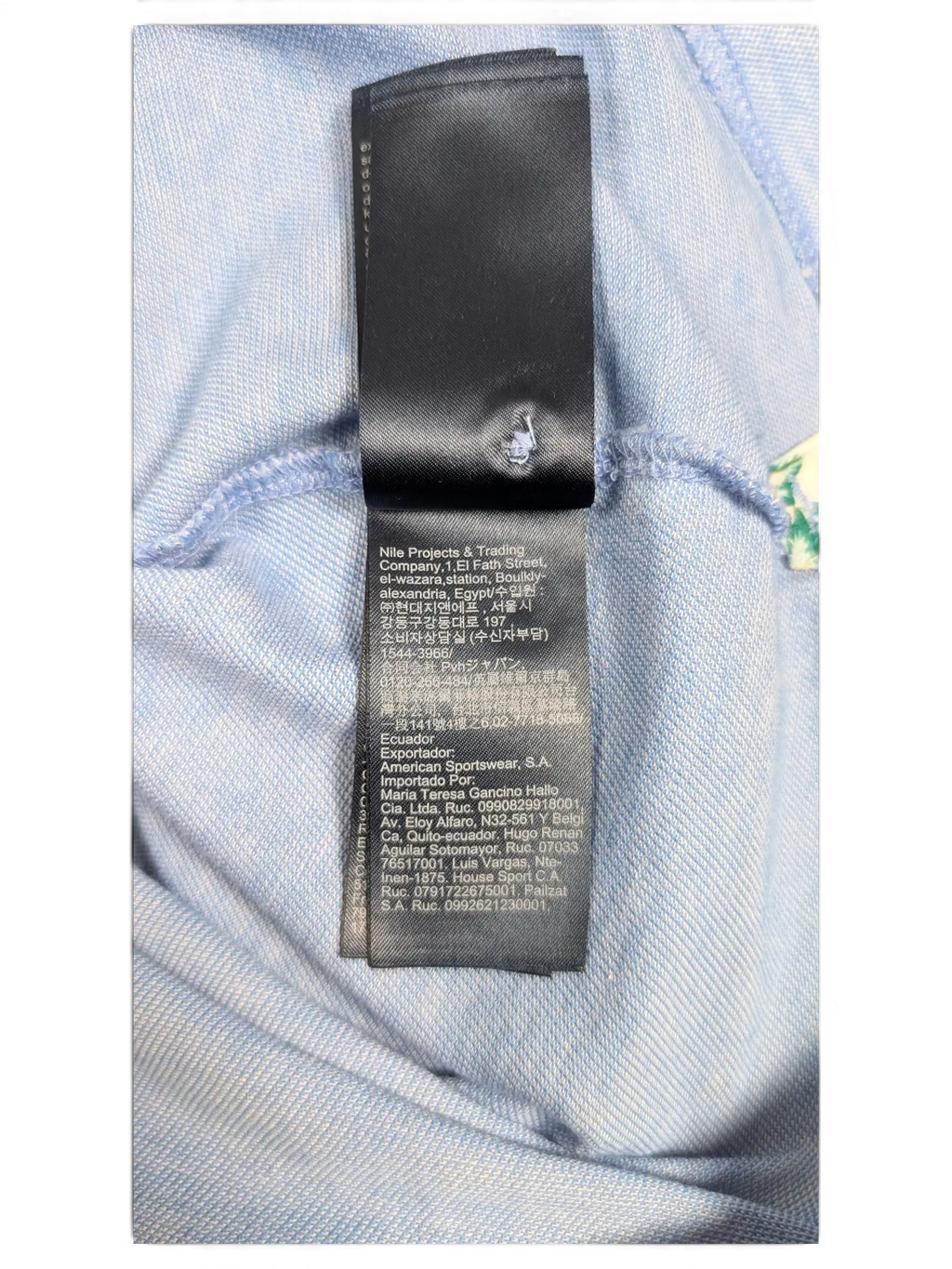JAKE & IPI Tommy Hilfiger light blue polo shirt interior care label with multi-language manufacturing information