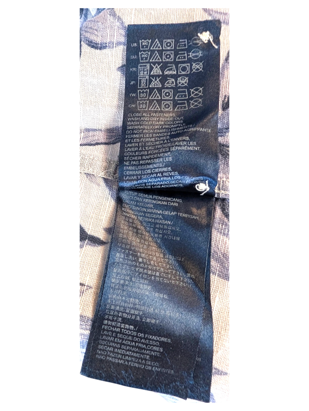 JAKE & IPI Tommy Hilfiger Hawaiian shirt interior care label with washing instructions on blue floral fabric