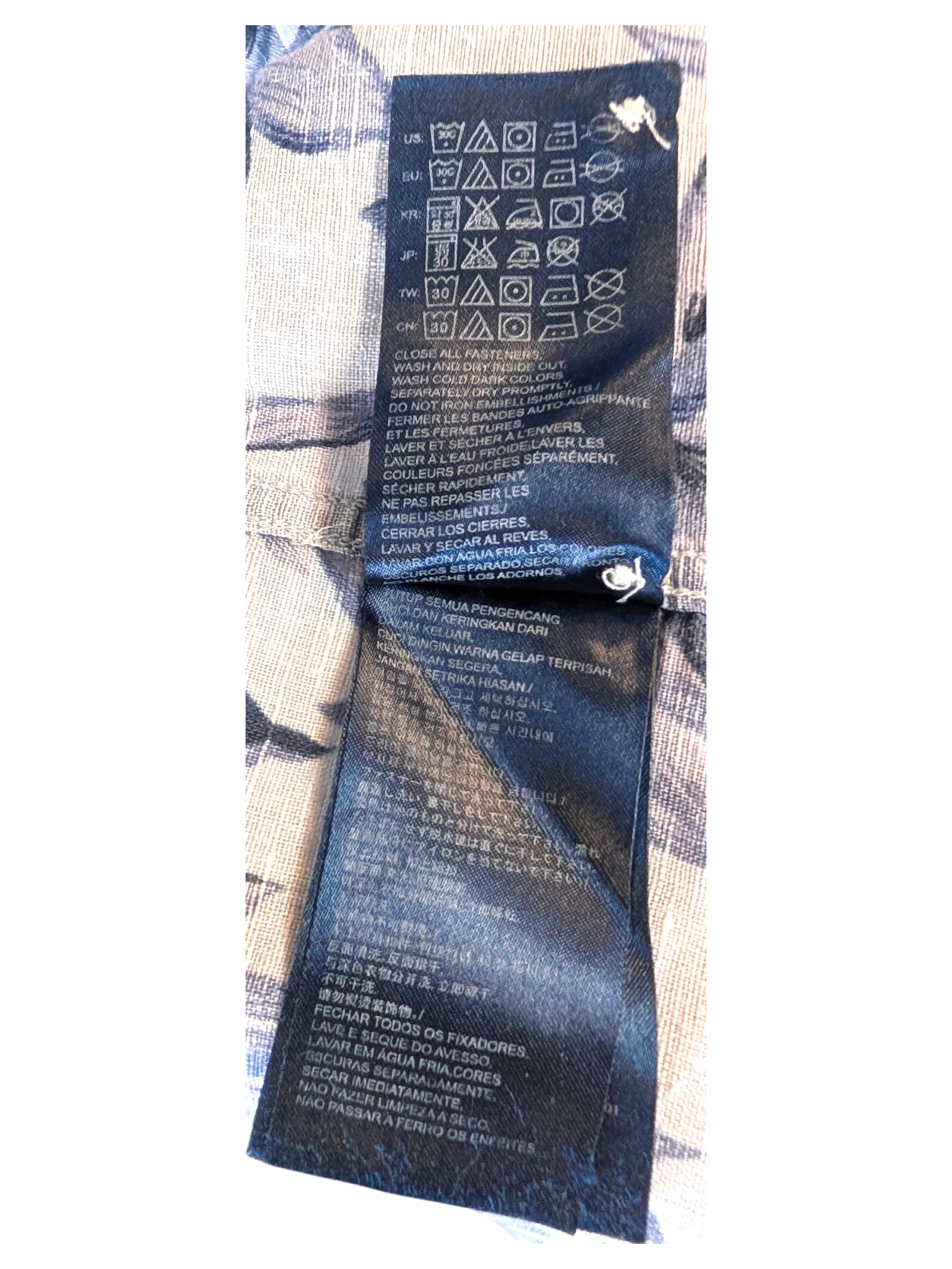 JAKE & IPI Tommy Hilfiger Hawaiian shirt interior care label with washing instructions on blue floral fabric