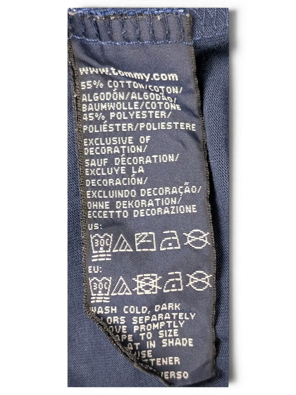 JAKE & IPI Tommy Hilfiger navy polo shirt fabric care label showing 55 percent cotton and 45 percent polyester blend