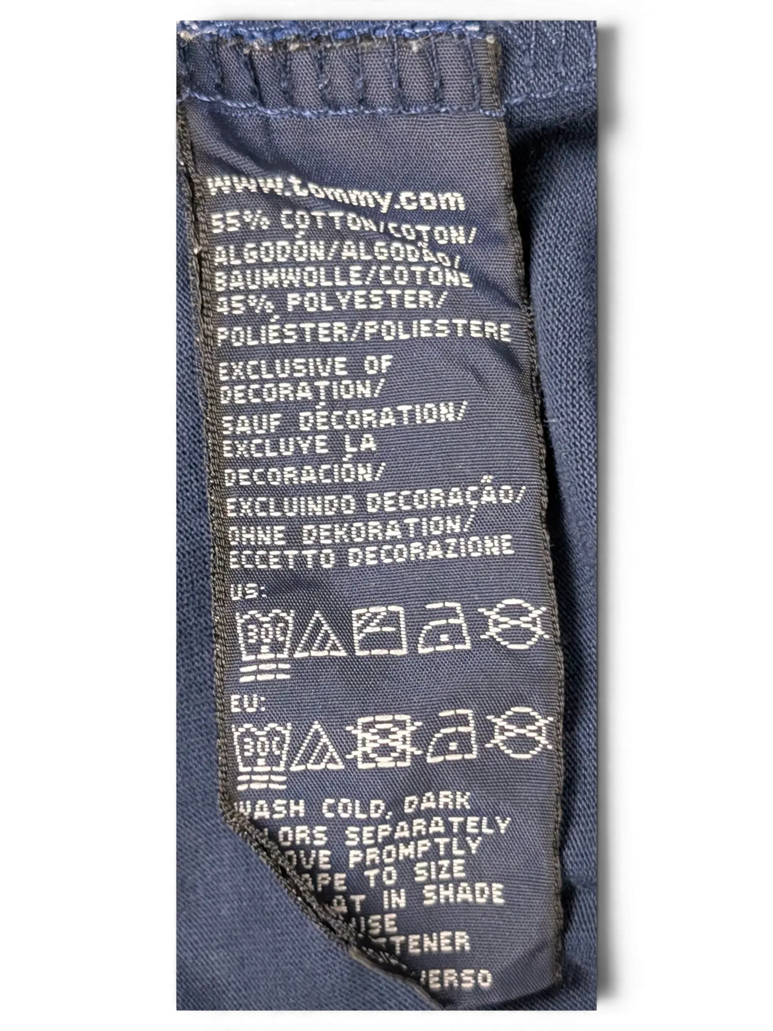 JAKE & IPI Tommy Hilfiger navy polo shirt fabric care label showing 55 percent cotton and 45 percent polyester blend